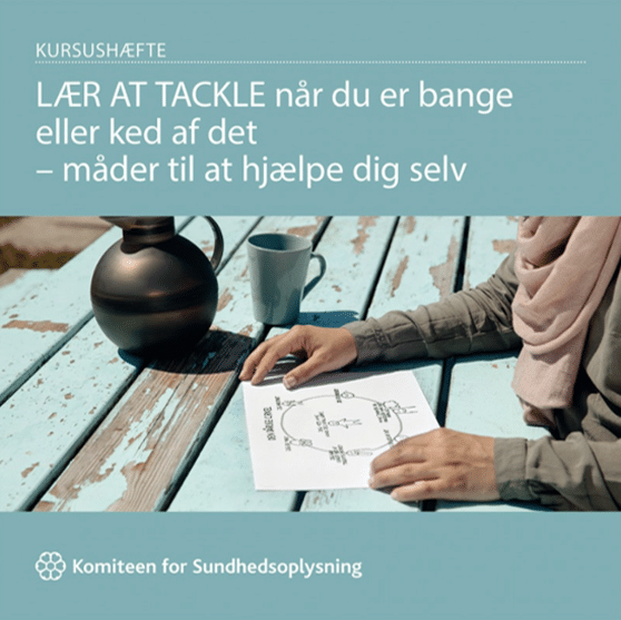 Forsiden af kursusbog tilknyttet kurset LÆR AT TACKLE når du er bange eller ked af det. Billedt viser en kvinde, der sidder ved et bord med en tegning foran sig.